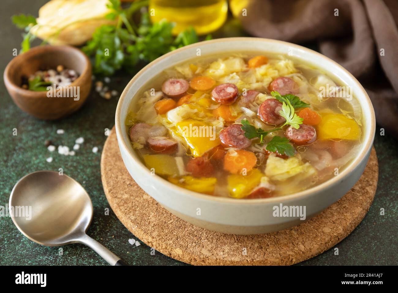 Traditionelle Zelnacka Kohlsuppe mit Würstchen und Gemüse in einer Schüssel auf einem Steintisch. Tschechische Küche. Stockfoto