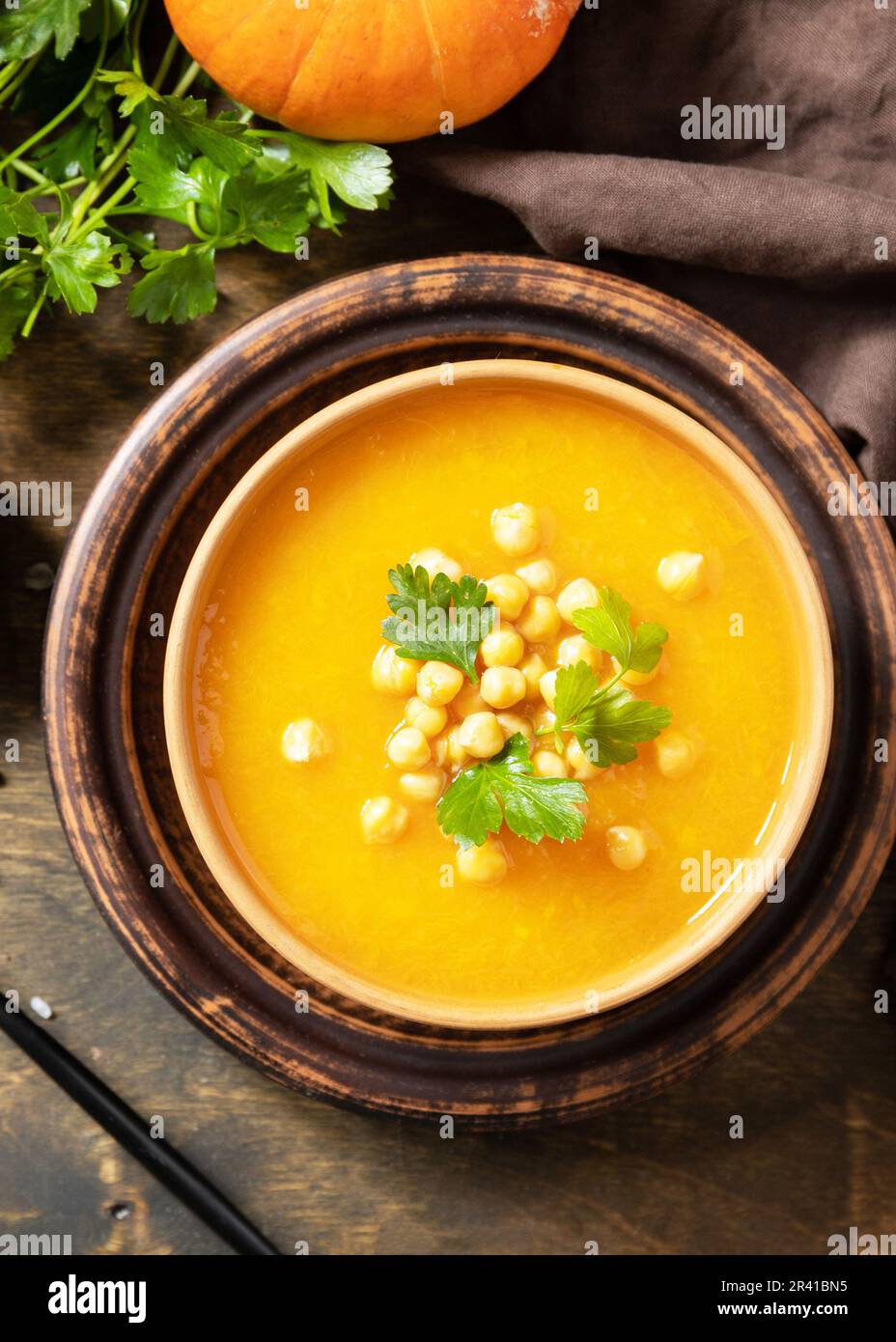 Comfort Food, Herbst und Winter gesundes Slow Food Konzept. Vegetarische Kürbis- und Kichererbsencremesuppe auf einem rustikalen Holztisch. Vi Stockfoto