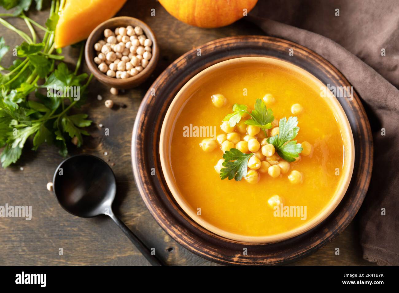 Comfort Food, Herbst und Winter gesundes Slow Food Konzept. Vegetarische Kürbis- und Kichererbsencremesuppe auf einem rustikalen Holztisch. Stockfoto