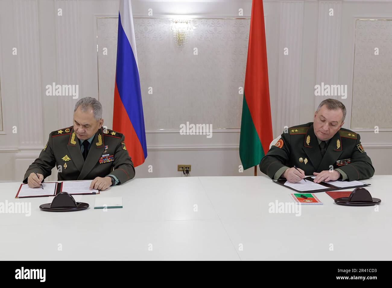Der russische Verteidigungsminister Sergei Shoigu, die Linke und der belarussische Verteidigungsminister Viktor Khrenin tauschen während einer Sitzung im Anschluss an eine Sitzung des Rates der Verteidigungsminister der Organisation für den Vertrag über kollektive Sicherheit (CSTO) in Minsk (Belarus) am Donnerstag, den 25. Mai 2023 Dokumente aus. Der belarussische Präsident Alexander Lukaschenko sagt, die Verlegung einiger taktischer Atomwaffen von Russland nach Belarus habe bereits begonnen, so die Nachrichtenagentur TASS. Foto: Pressedienst des russischen Verteidigungsministeriums/Kredit: UPI/Alamy Live News Stockfoto