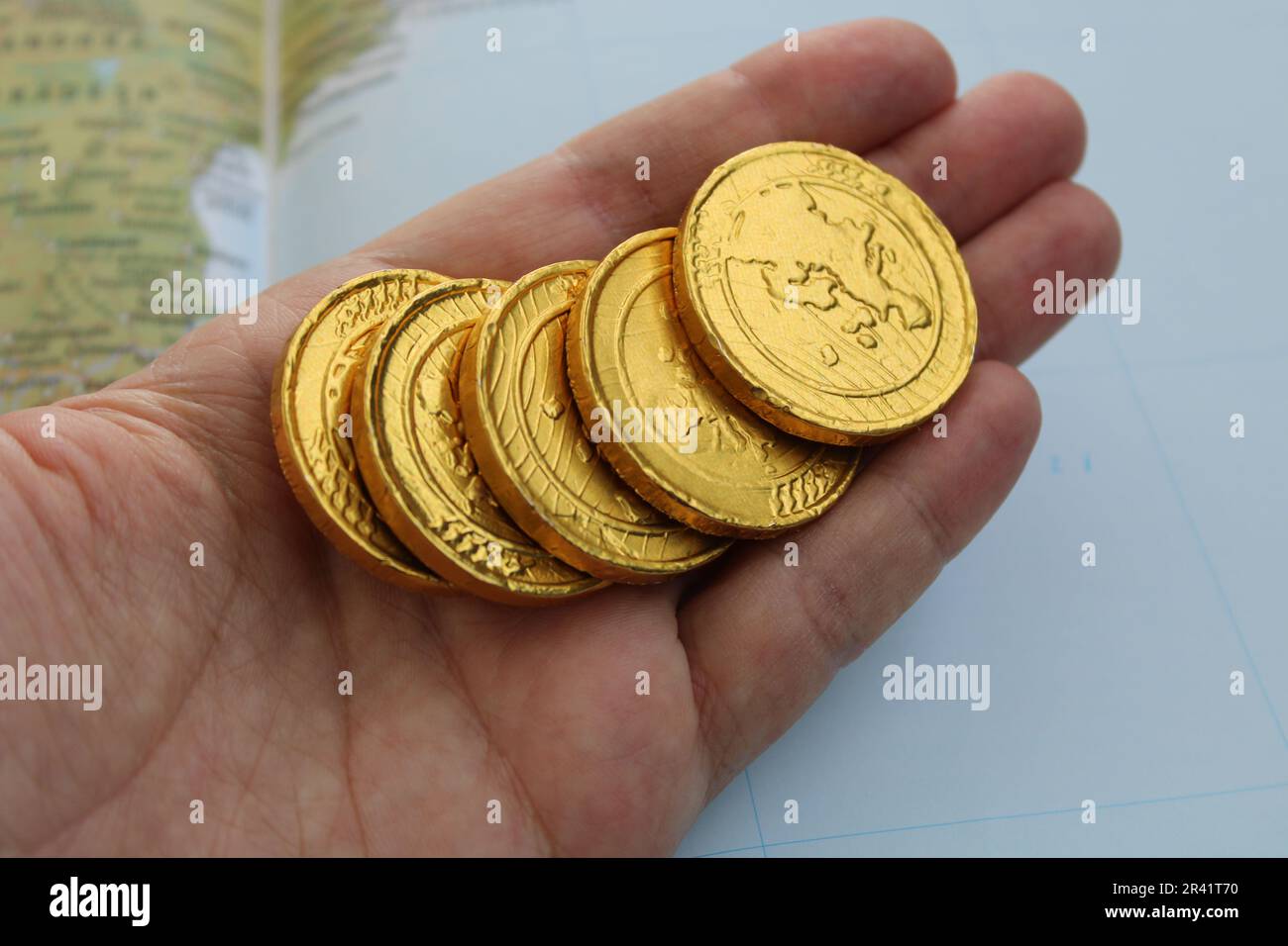 Eine Hand hält eine Goldmünze mit dem Wort Drache drauf. Stockfoto