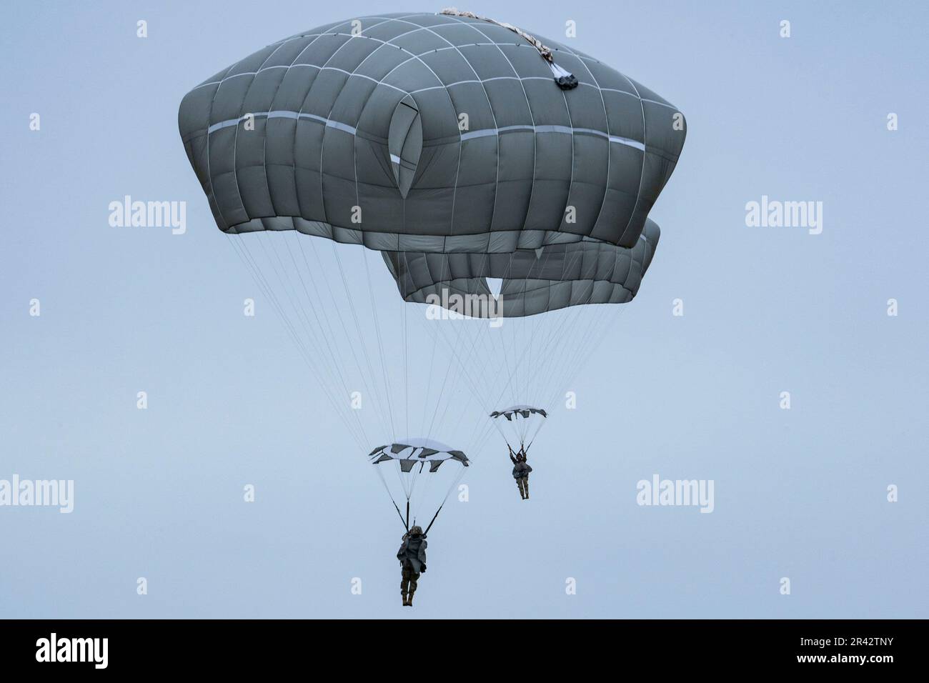 Zwei US-Dollar Fallschirmjäger der Armee, die dem 2. Infanterie-Brigaden-Kampfteam (Airborne), 11. Luftwaffe, ‚Arctic Angels‘, zugeteilt sind, steigen nach dem Sprung aus den USA ab Marine Corps Reserve KC-130J Hercules zugewiesen an Marine Aerial Tanken Transportgeschwader 234 (VMGR-234), Naval Air Station Joint Reserve Base, Fort Worth, Texas, in Malemute Drop Zone, Joint Base Elmendorf-Richardson, Alaska, 24. Mai 2023, Zu Ehren der Spartanischen Gedenkwoche. Fallschirmjäger trugen die Namensschilder von 77 gefallenen Fallschirmjägern, die bei Einsätzen in Afghanistan und Irak das ultimative Opfer brachten. Dann Fallschirmjäger Stockfoto