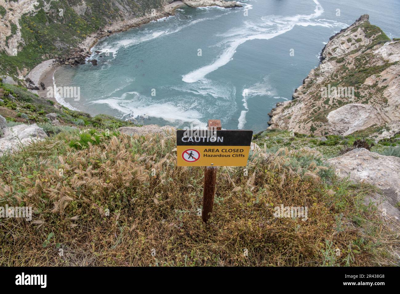 Ein Schild warnt Besucher vor gefährlichen Klippen und gefährlichen Wasserfällen am Potato Harbor Overlook im Channel Islands National Park, Kalifornien. Stockfoto