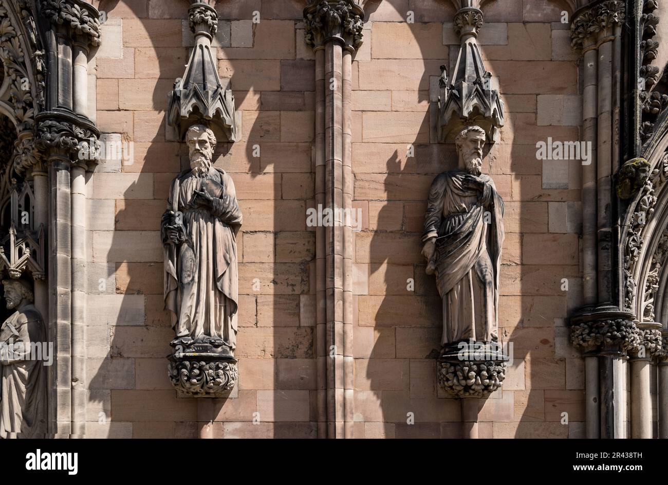 Steinschnitzereien schmücken die Westfront der Kathedrale von Lichfield. Die Skulpturen zeigen die Apostel Paul und Matthew. Stockfoto