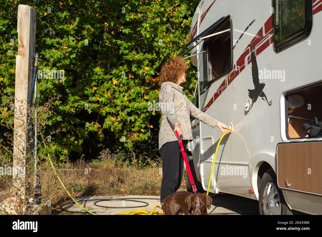 Eine Frau, die den Wassertank eines Wohnwagens füllt. Stockfoto