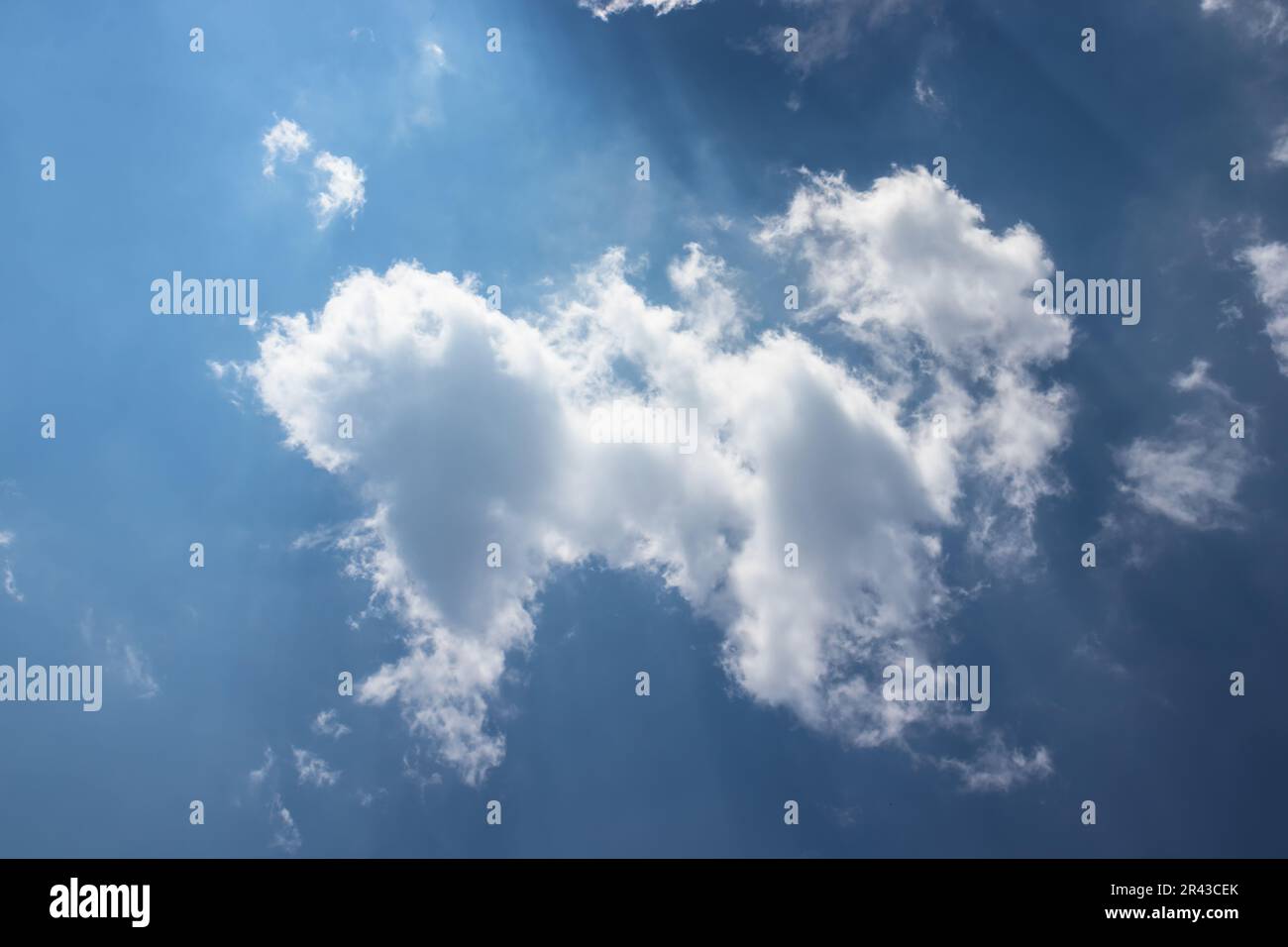 Blauer Himmel mit weißen Wolken und Sonnenstrahlen. Abstrakter Hintergrund. Stockfoto