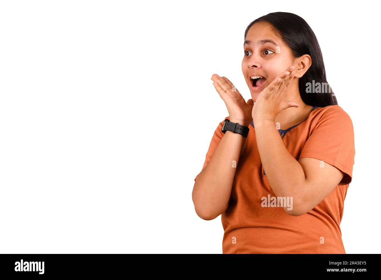 Bild einer aufgeregten jungen Indianerin, die isoliert auf weißem Hintergrund steht, mit Copy Space. Ich sehe in die Kamera. Stockfoto