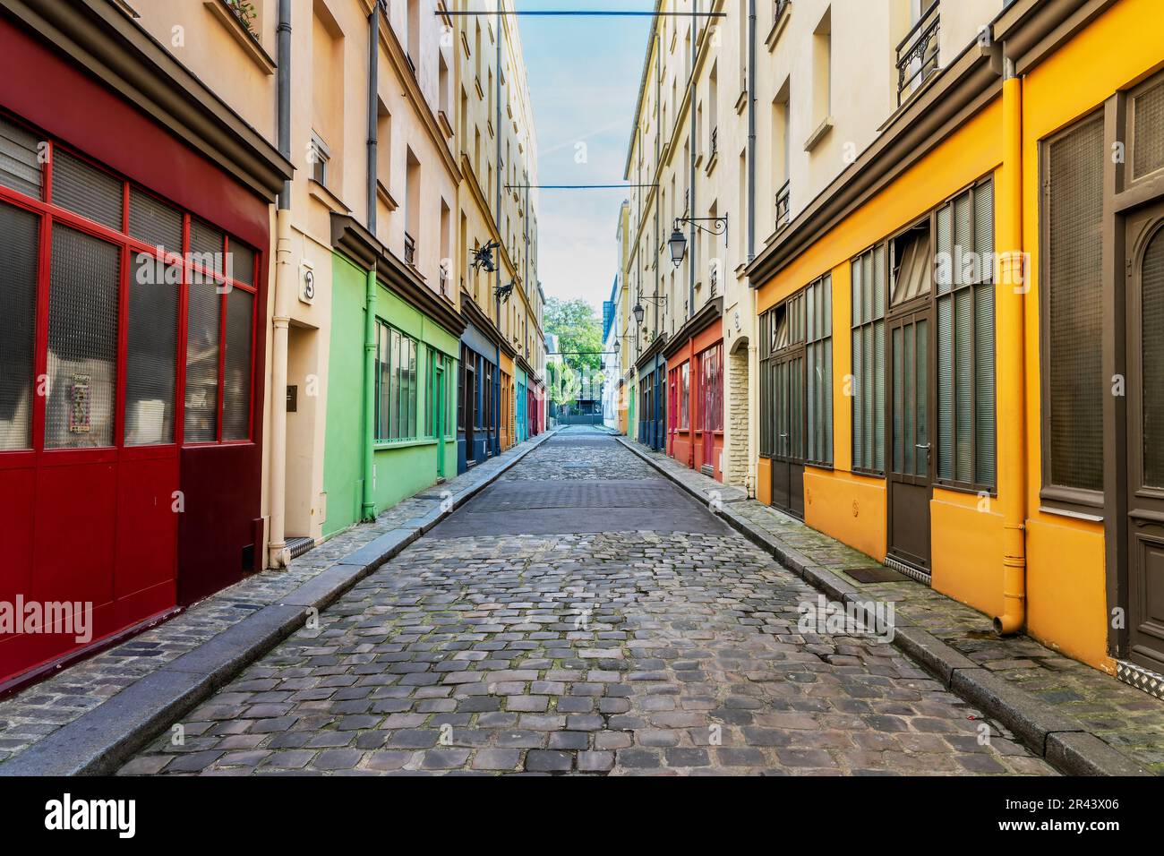 Farbenfrohe Vintage-Werkstätten und Kunststudios in einer kleinen Kopfsteinpflasterstraße in Paris, Frankreich Stockfoto