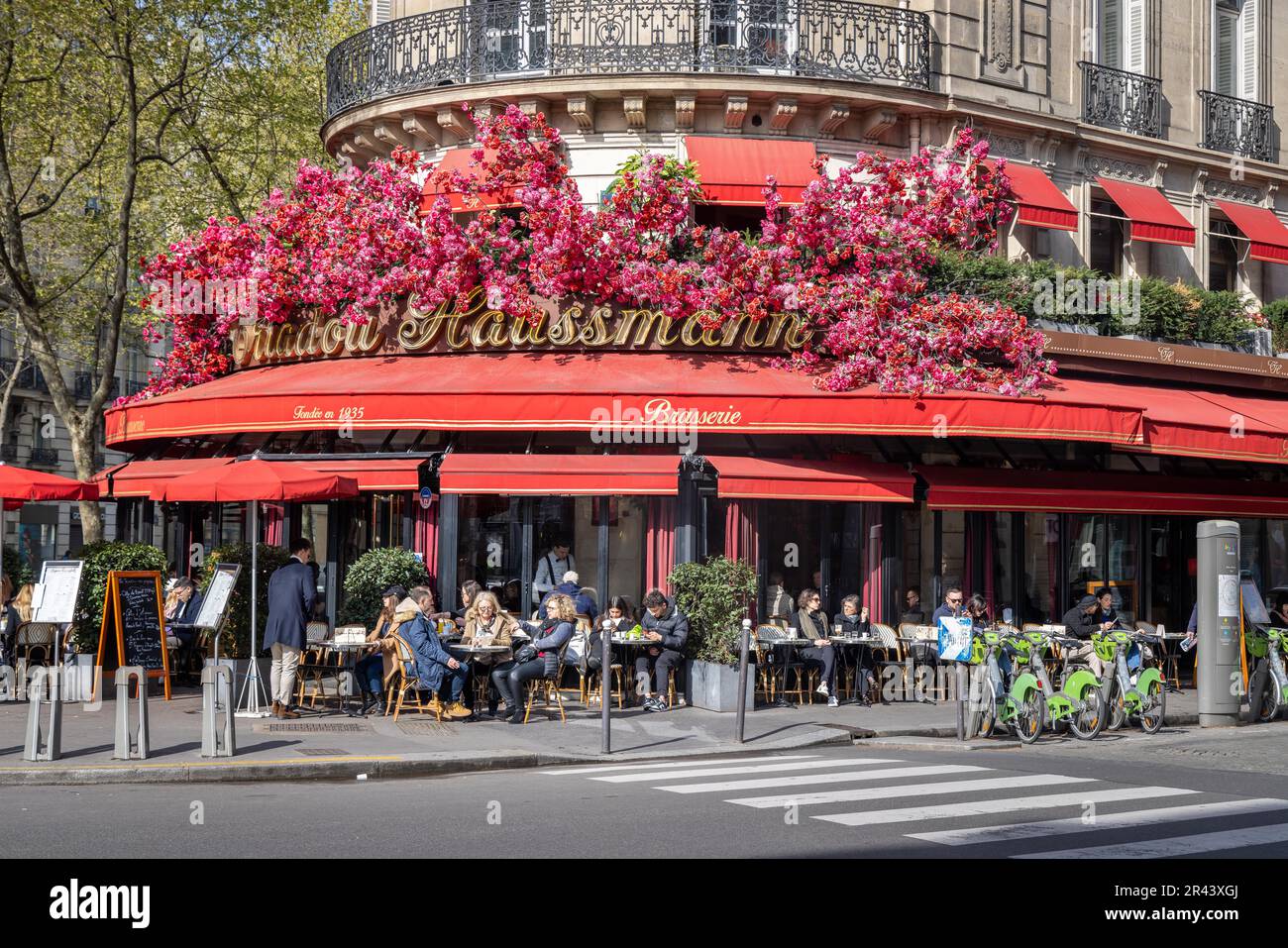 Mit Blumen verzierte Fassade im Straßencafé Triadou Haussmann, Boulevard Haussmann, Paris, Frankreich Stockfoto