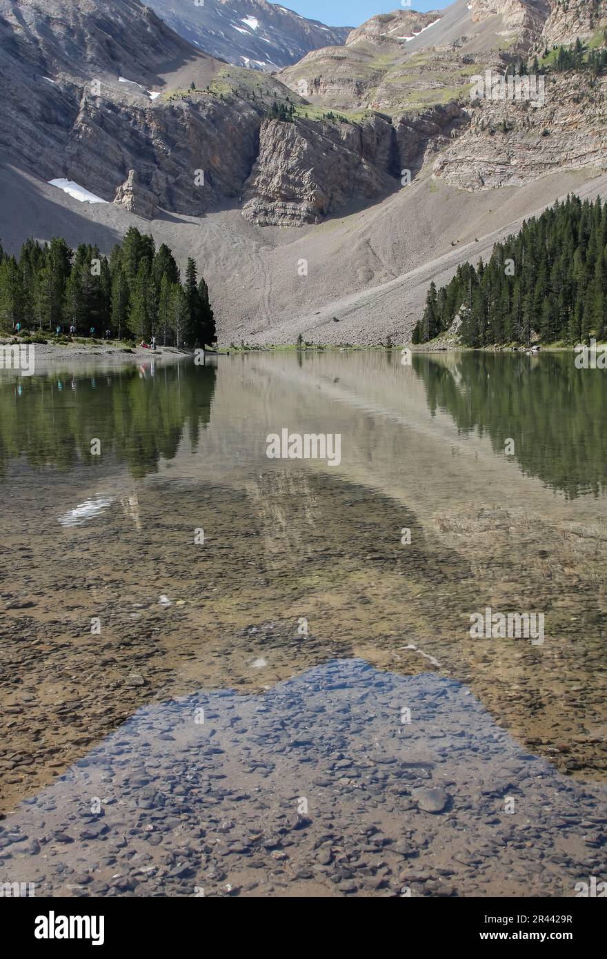 Reflexionen im Wasser der Berge und Bäume in Ibon de Plan Stockfoto