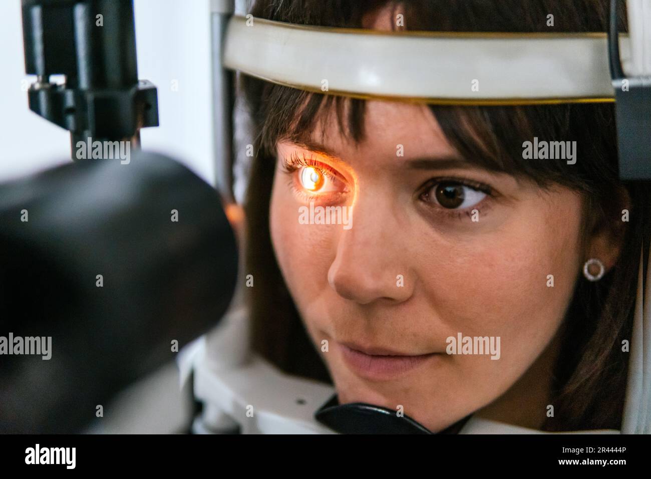 Augenarzt, der einem Patienten mit einer Maschine ins Auge sieht Stockfoto