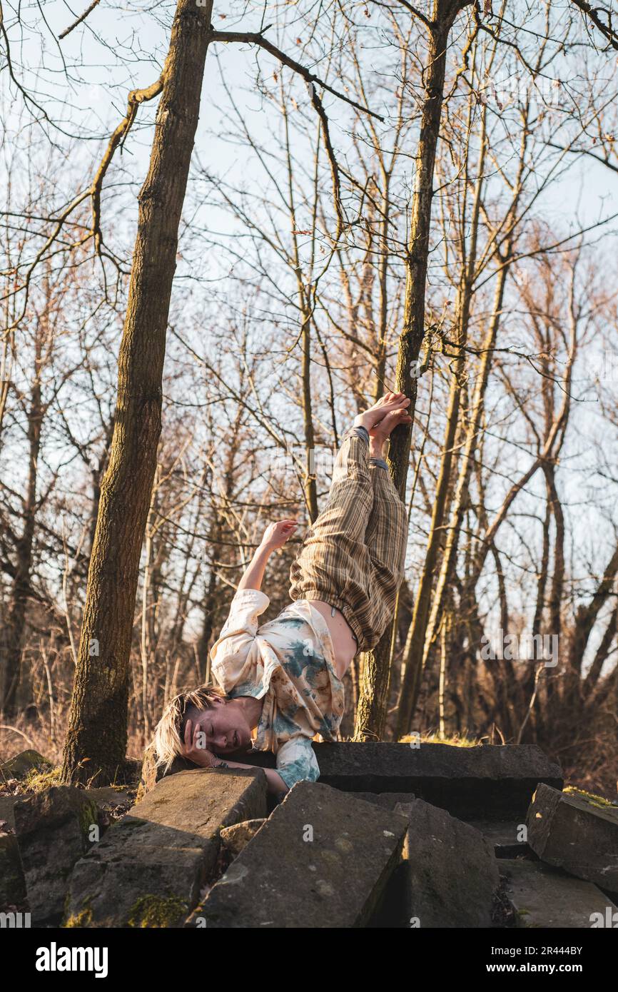 Tänzer balancieren in starkem Halt auf Steinen im Winterwald Stockfoto