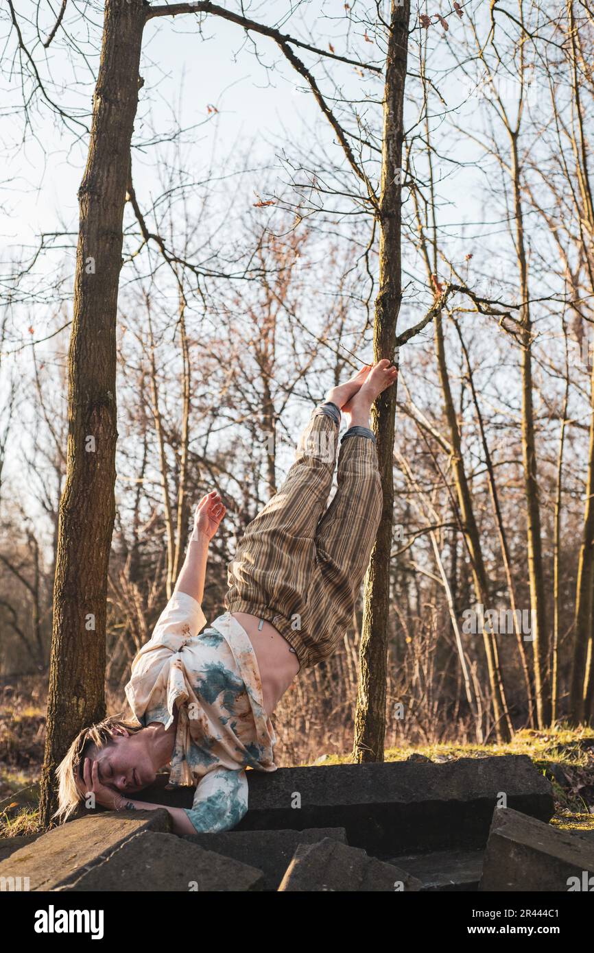 Eine starke Sporttänzerin balanciert anmutig auf einer Schulter im Wald Stockfoto