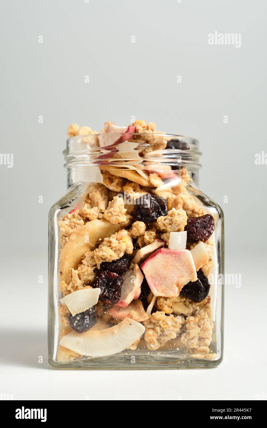 Köstliches Frühstücksmüsli mit getrockneter Kokosnuss, Banane, Apfel, Cranberries und Rosinen. Stockfoto