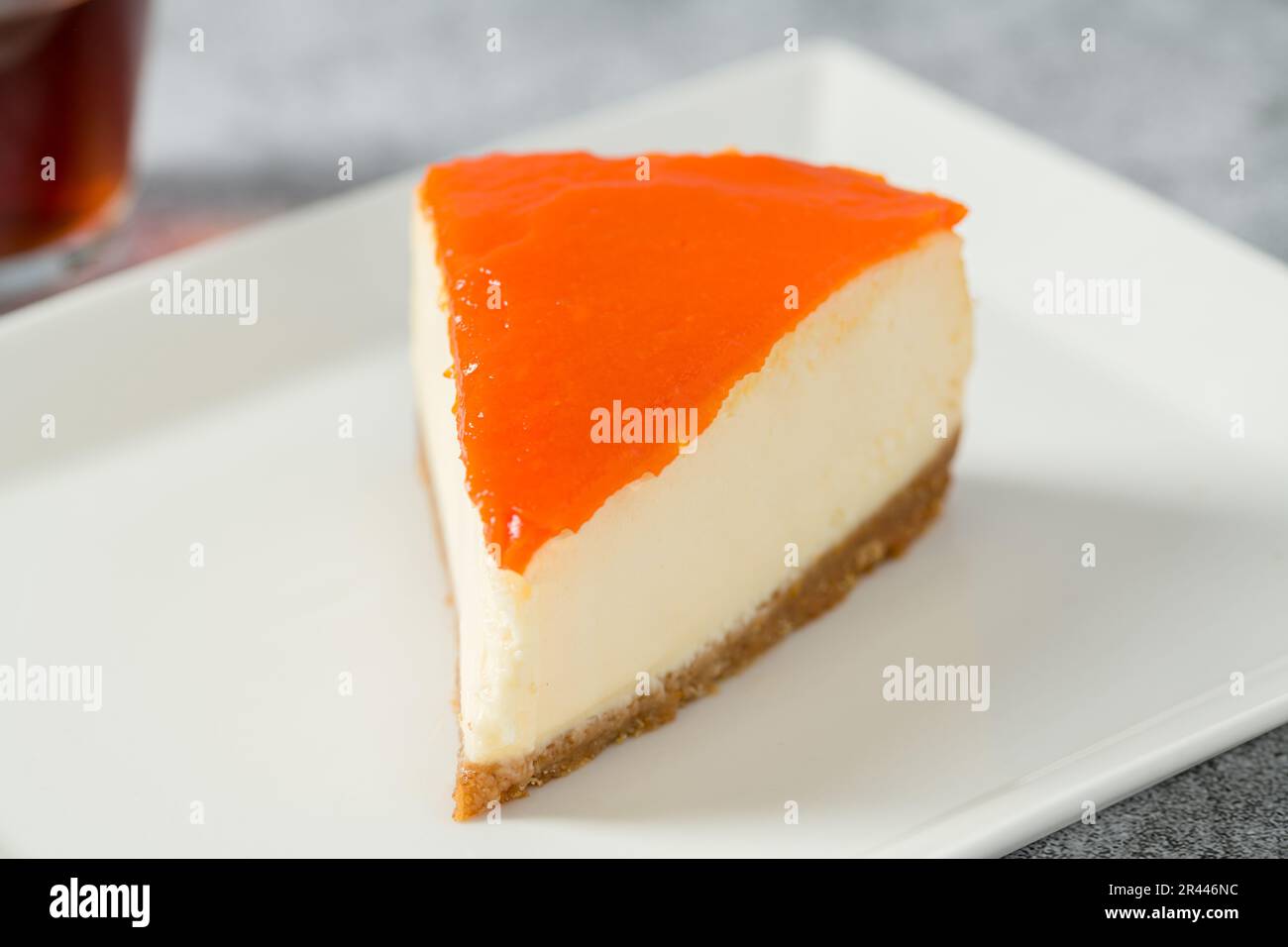 Kürbiskäsekuchen auf Porzellanteller mit Tee auf Steintisch Stockfoto