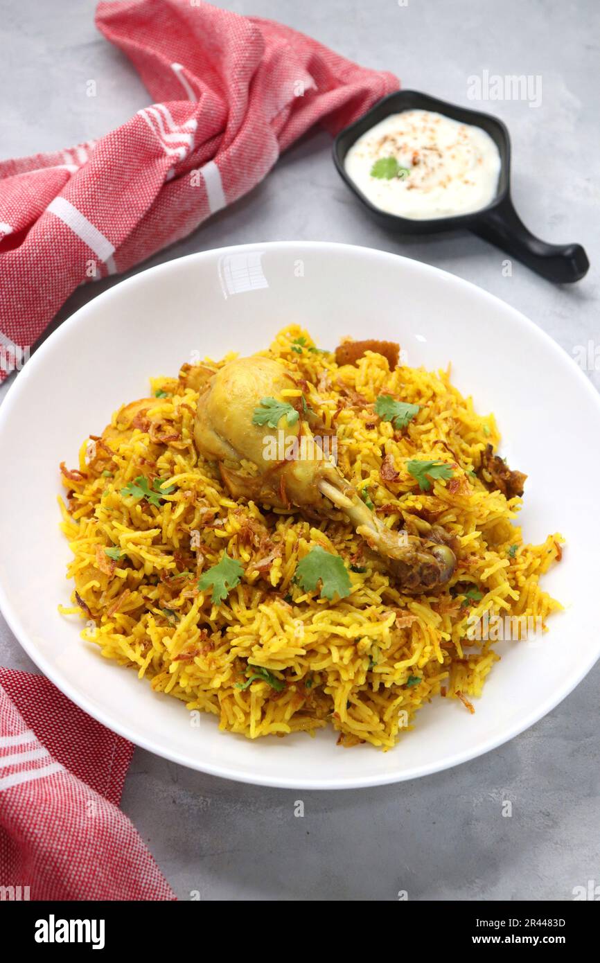 Hühnchen Biryani/murg Pulao. Garniert mit gebratenen Zwiebeln und gehacktem Koriander. Biryani serviert mit Rita ist ein berühmtes würziges nicht-vegetarisches Gericht Indiens. Stockfoto