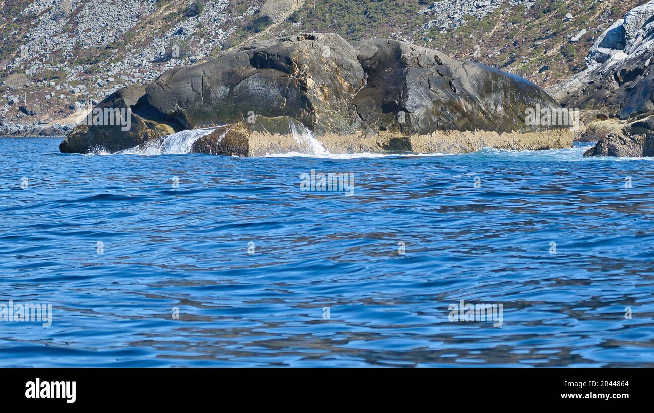 norwegen auf dem Fjord, auf Felsen sprühen. Wasser spritzt auf die Steine. Küstenlandschaft in Skandinavien. Landschaftsfoto aus dem Norden Stockfoto