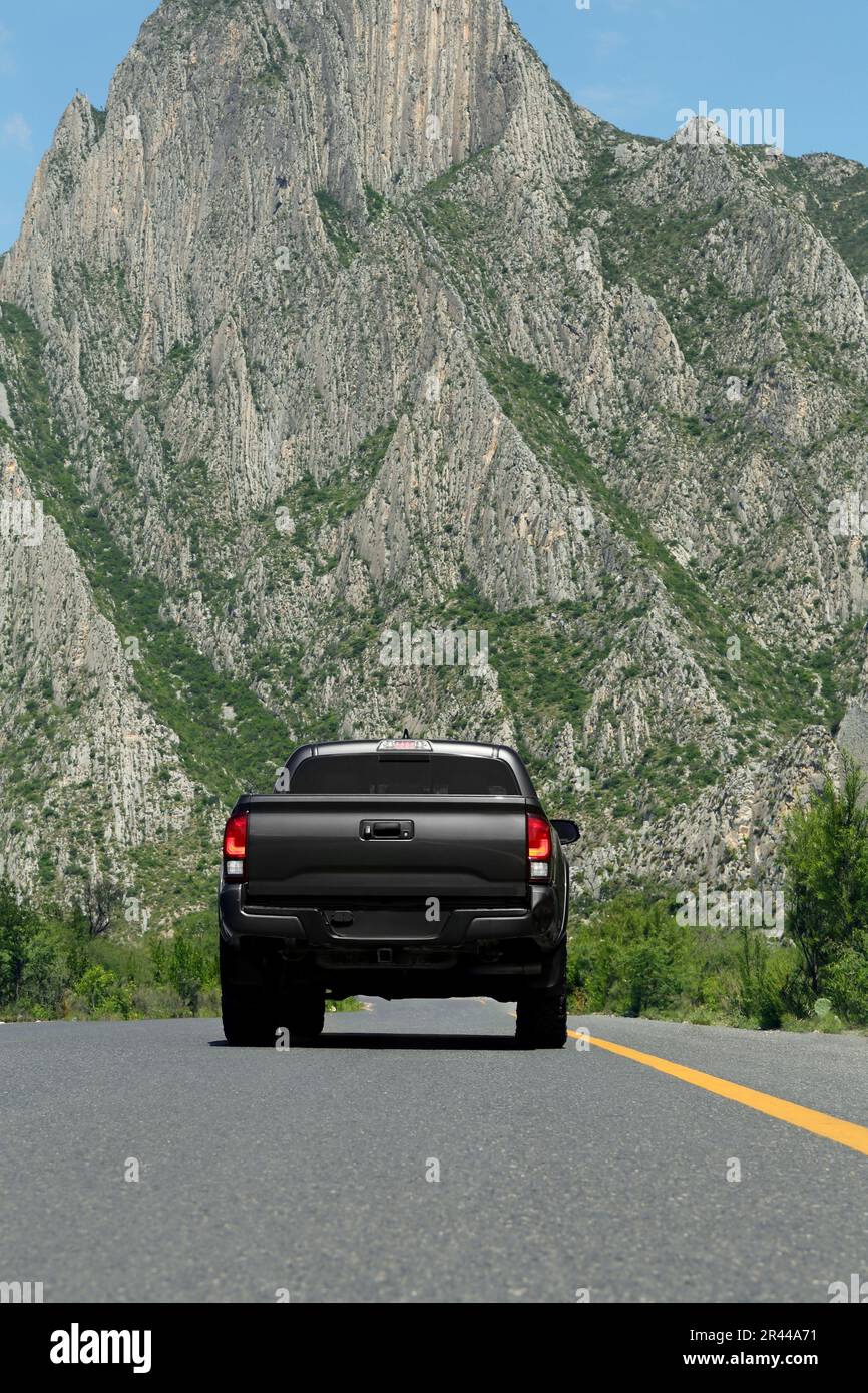 Schwarzes Auto auf der Straße in der Nähe der wunderschönen Berge im Freien Stockfoto