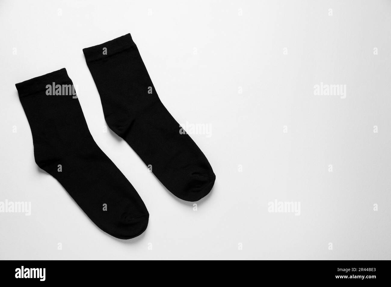 Schwarze Socken auf weißem Hintergrund, flach liegend. Platz für Text Stockfoto