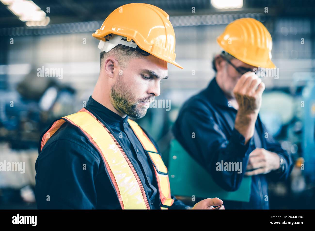 Teamarbeit männlicher junger Arbeiter in der Schwerindustrie mit Schutzanzug Schutzhelm Stockfoto