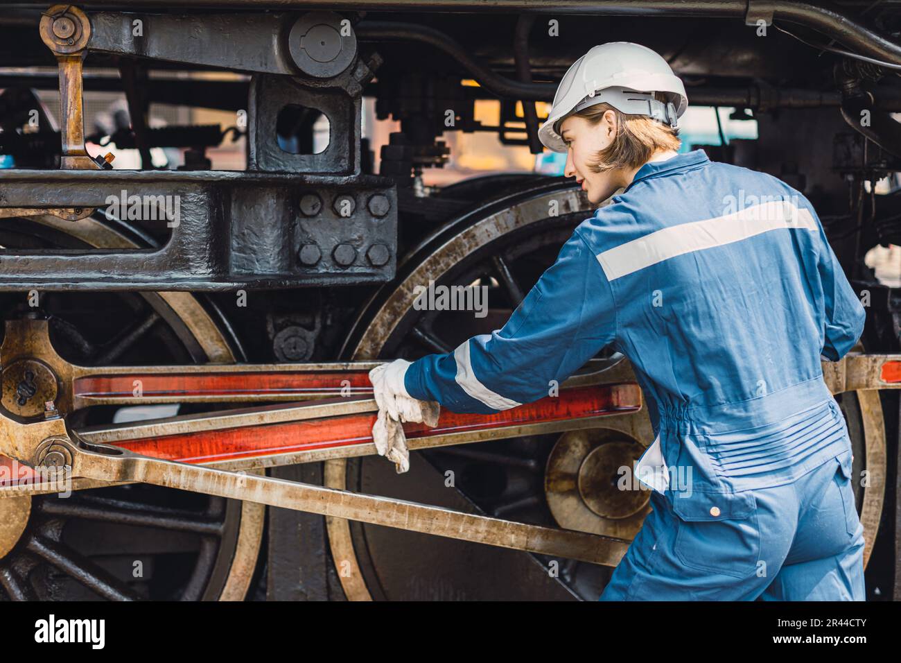 Zugingenieur-Team arbeitet Service Wartung alte schmutzige klassische Dampflokomotive in der Bahnhofswerkstatt. Stockfoto