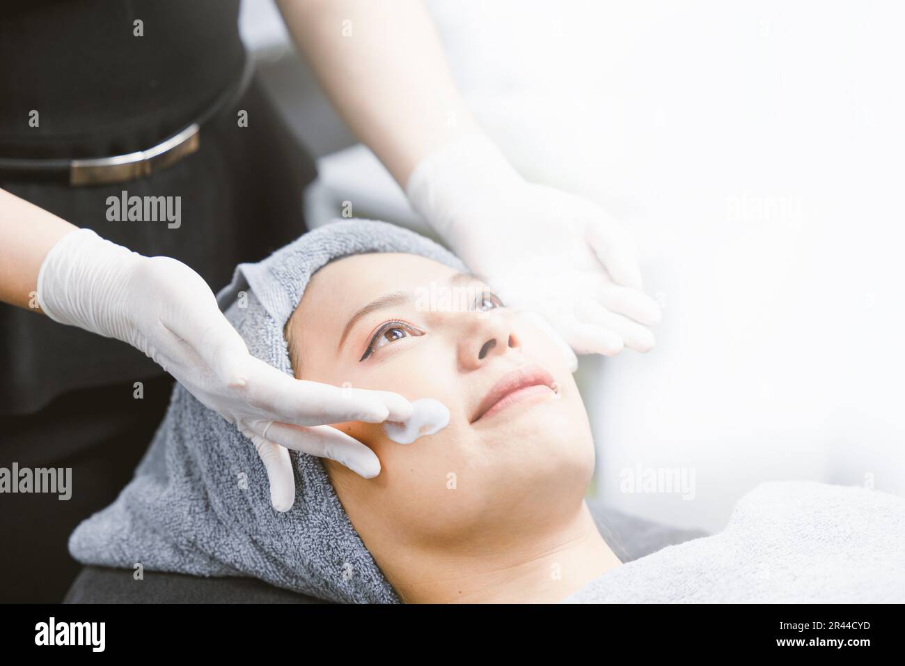 Gesichtsmassage Frau Gesichtspflege Hautpflegecreme Behandlung im Spa mit weißer Fläche für Werbetext. Stockfoto