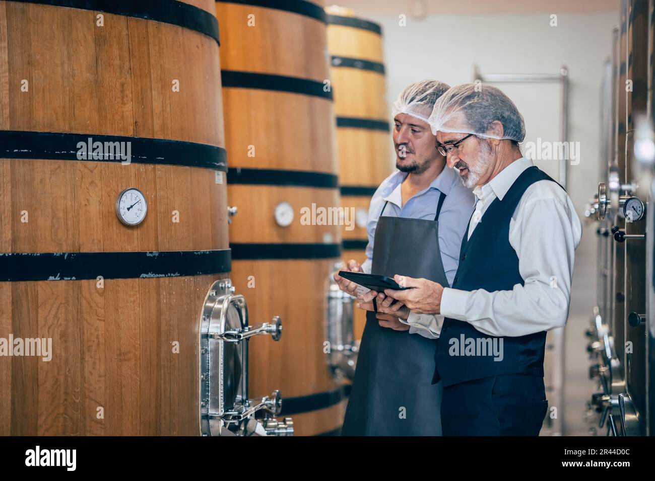 Winzer, der in einer modernen großen Weinfabrik arbeitet, überwacht Qualität und Gärung der Spirituosenindustrie Stockfoto
