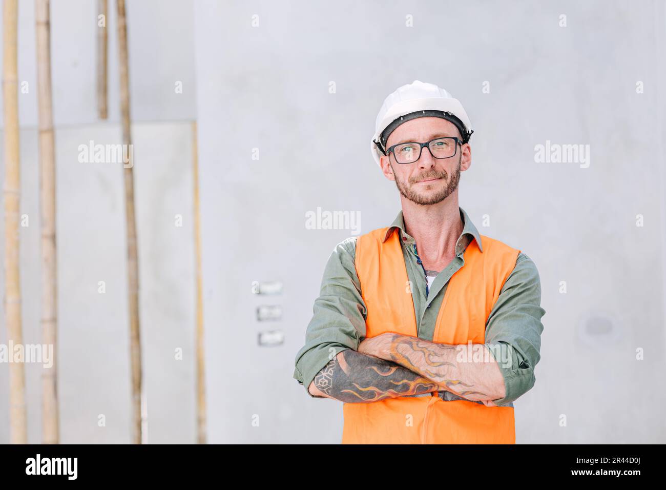 Portrait Hipster Arbeiter Cosntruction Ingenieur Architect. bauarbeiter auf der Baustelle intelligenter Arm gekreuzt selbstbewusstes Lächeln. Stockfoto
