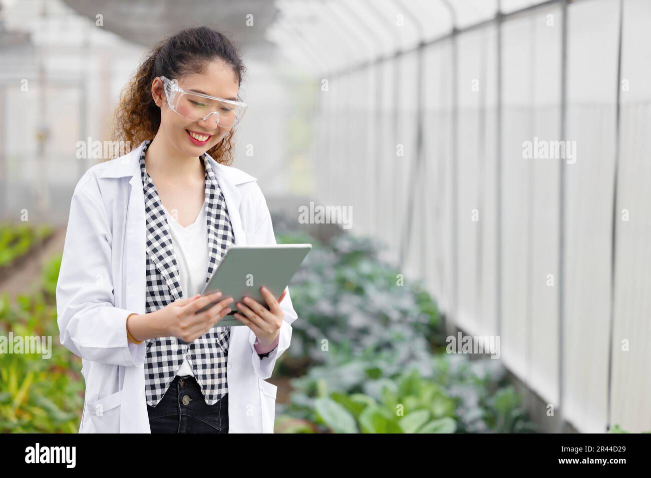 Happy Lächeln Scientist Modern Farmer verwendet Tablet Monitor Landwirtschaft Farm Plant Research Working. Stockfoto