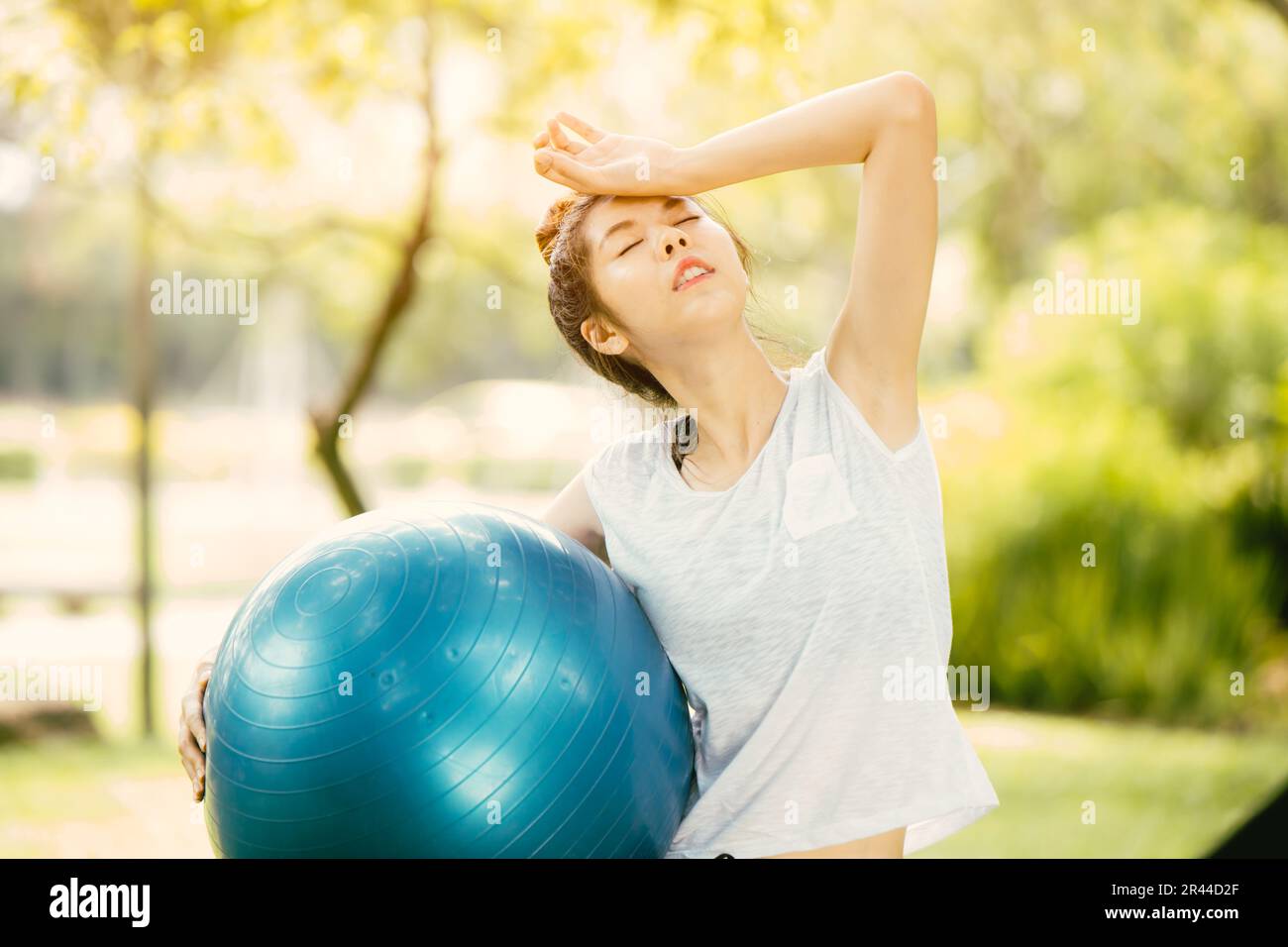 Sportliche Frauen trainieren im Freien fühlen sich krank Kopfschmerzen wegen der Hitze von der heißen Sommersaison Stockfoto