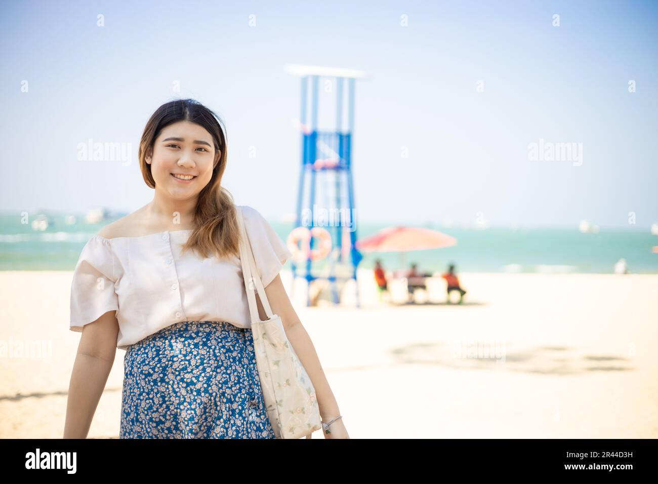 Glückliche asiatische gesunde, dicke Frau reisen am Sommerstrand. Porträtieren Sie lächelnde Menschen Stockfoto