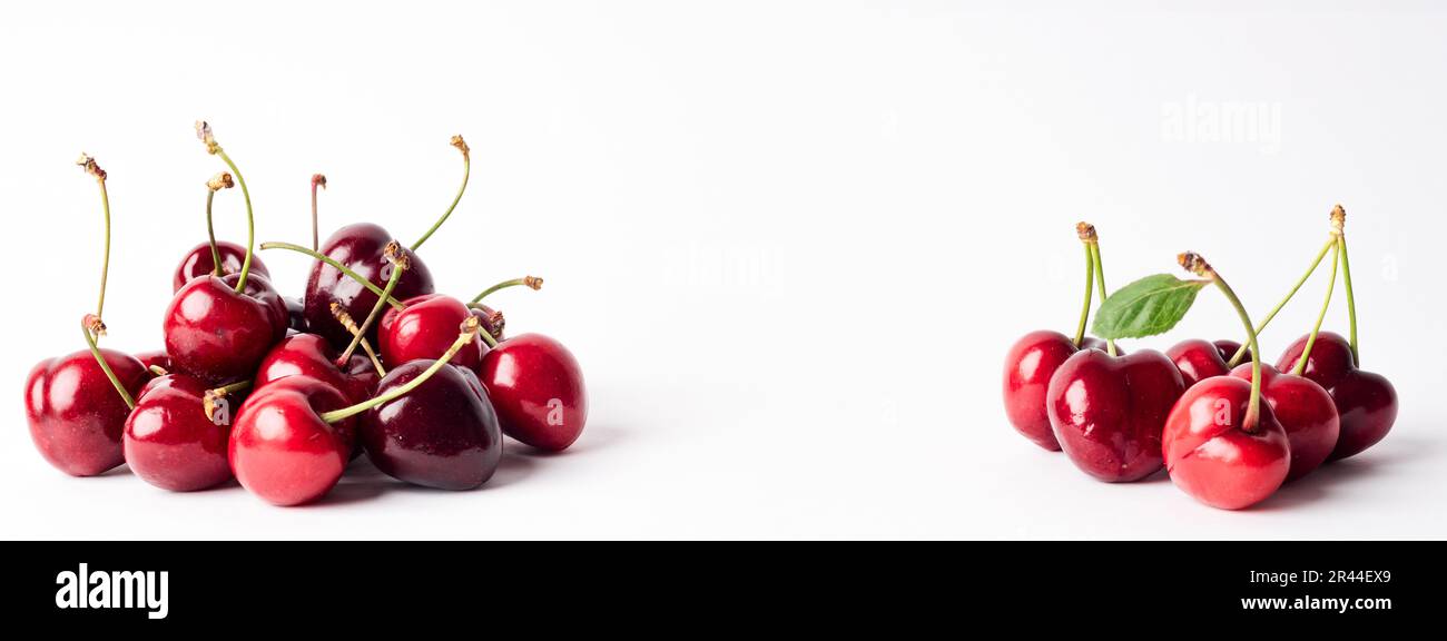 Banner mit einer Reihe von reichen und gesunden roten Kirschen auf weißem Hintergrund. Tapete für frisch gepflückte Kirschen Stockfoto