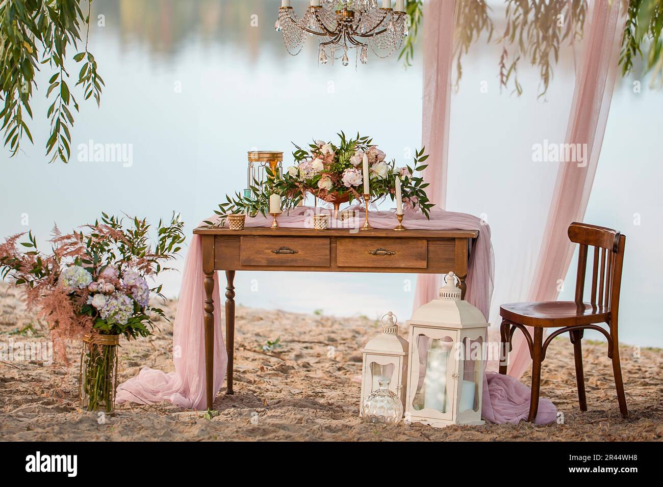 Wunderschöne Hochzeitsdekoration. Hochzeit am Strand, Roses Retro-Stil. Hochzeitsfloristik Dekoration Stockfoto