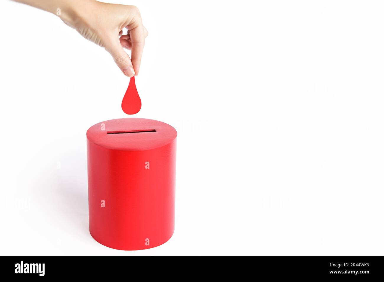 Blutspender. Die Hand legt einen Blutstropfen als Spende in die Kiste. Konzept Spende Blut rettet Leben. Speicherplatz kopieren Stockfoto