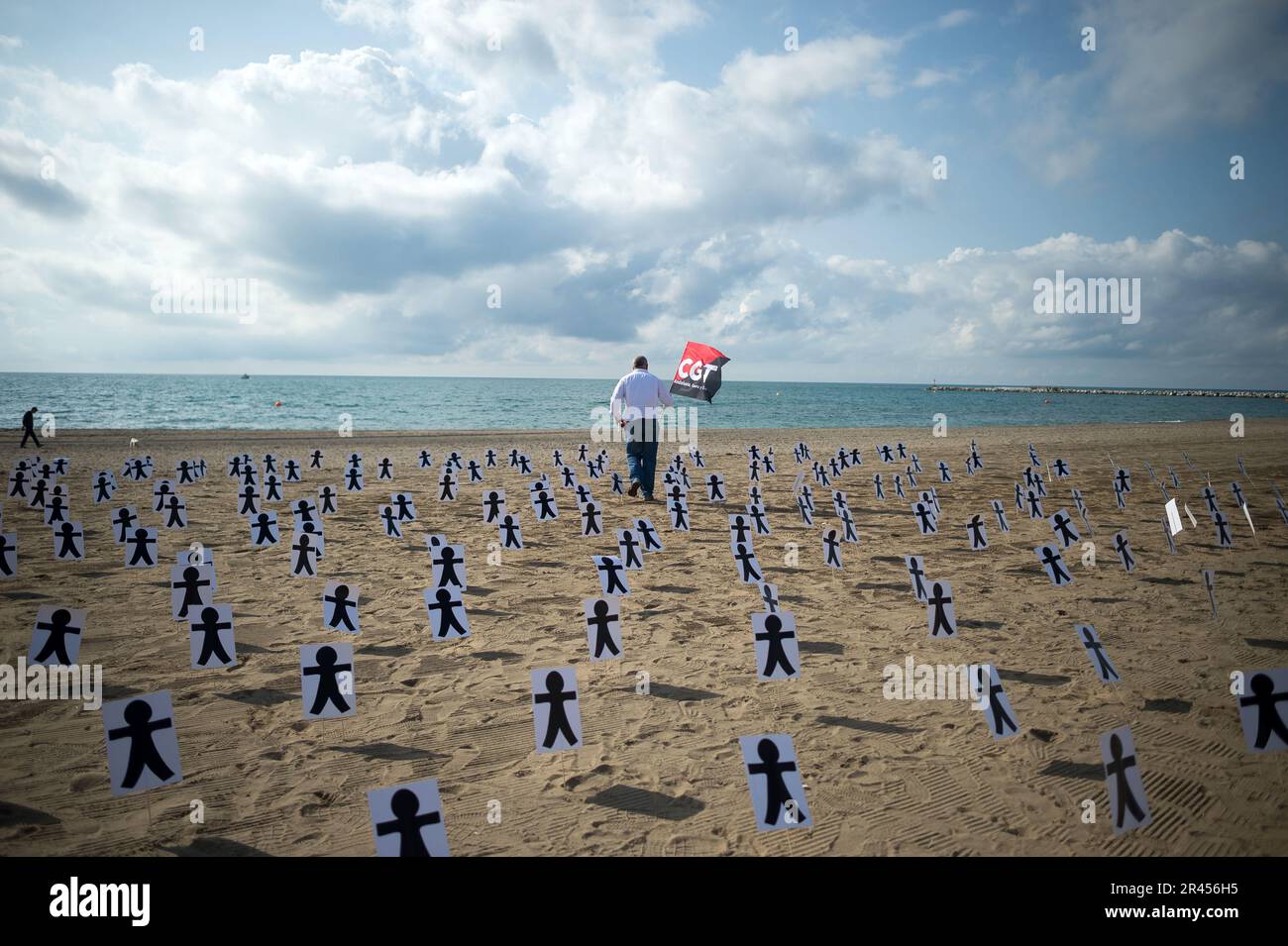 Malaga, Spanien. 26. Mai 2023. Ein Protestteilnehmer mit einer CGT-Flagge, der an Plakaten am Strand von La Misericordia vorbeigelaufen ist, nimmt an einer Hommage an Arbeitern Teil, die im Jahr 2022 in Andalusien bei Arbeitsunfällen starben. Dutzende von Personen, die von der Allgemeinen Arbeiterkonferenz aufgerufen wurden, haben gezeigt, dass sie Sicherheitsmaßnahmen und Unfallverhütung am Arbeitsplatz sowie eine symbolische Hommage am Strand fordern. (Foto: Jesus Merida/SOPA Images/Sipa USA) Guthaben: SIPA USA/Alamy Live News Stockfoto