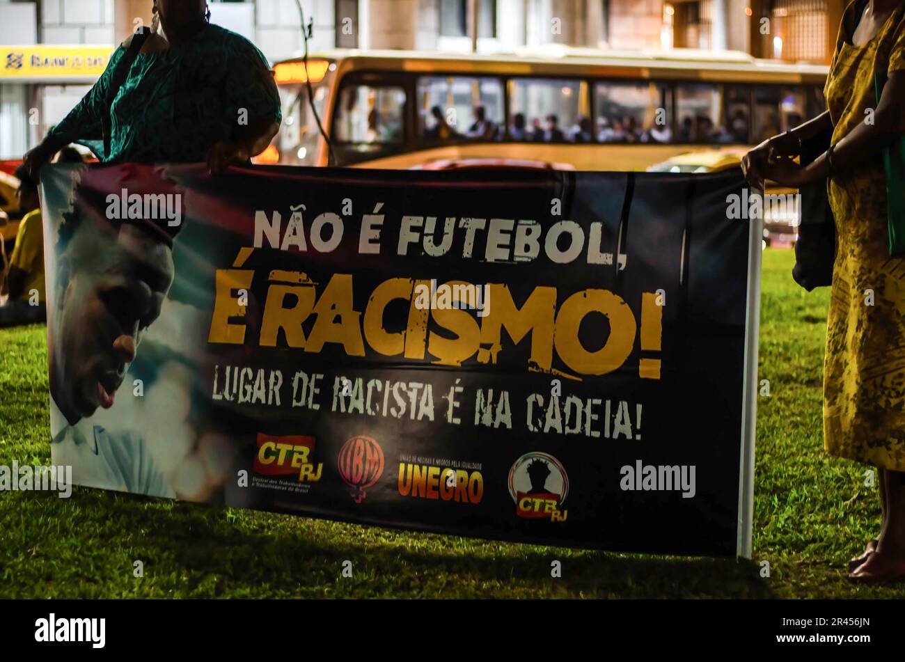 Demonstranten halten ein Banner, auf dem steht: "Nicht Fußball ist Rassismus!" Rassistischer Platz ist während der Demonstration im Gefängnis. Manifestation in der Stadt Rio de Janeiro, in Solidarität mit Real Madrids Spieler Vinícius Júnior, der in Spanien während eines Spiels gegen das Team von Valencia am Sonntag (21) Rassismus erlitt. Vinícius Jr. war Opfer von Rassismus und Gewalt, als er während des Spiels von mehreren Fußballfans und Gegnern als „Mono“ (Übersetzung zu „Affe“) bezeichnet wurde. Er wurde später aus dem Spiel geworfen. Vinicius Junior hat bereits acht Fälle von Rassismus, die von La Liga noch bearbeitet werden. Stockfoto