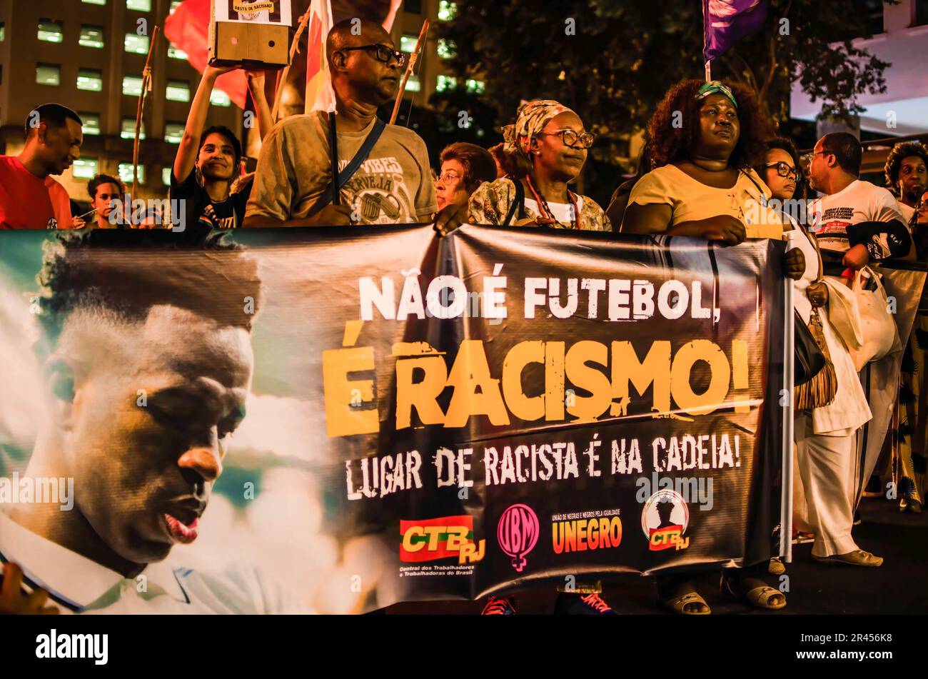 Demonstranten halten ein Banner, auf dem steht: "Nicht Fußball ist Rassismus!" Rassistischer Platz ist während der Demonstration im Gefängnis. Manifestation in der Stadt Rio de Janeiro, in Solidarität mit Real Madrids Spieler Vinícius Júnior, der in Spanien während eines Spiels gegen das Team von Valencia am Sonntag (21) Rassismus erlitt. Vinícius Jr. war Opfer von Rassismus und Gewalt, als er während des Spiels von mehreren Fußballfans und Gegnern als „Mono“ (Übersetzung zu „Affe“) bezeichnet wurde. Er wurde später aus dem Spiel geworfen. Vinicius Junior hat bereits acht Fälle von Rassismus, die von La Liga noch bearbeitet werden. Stockfoto