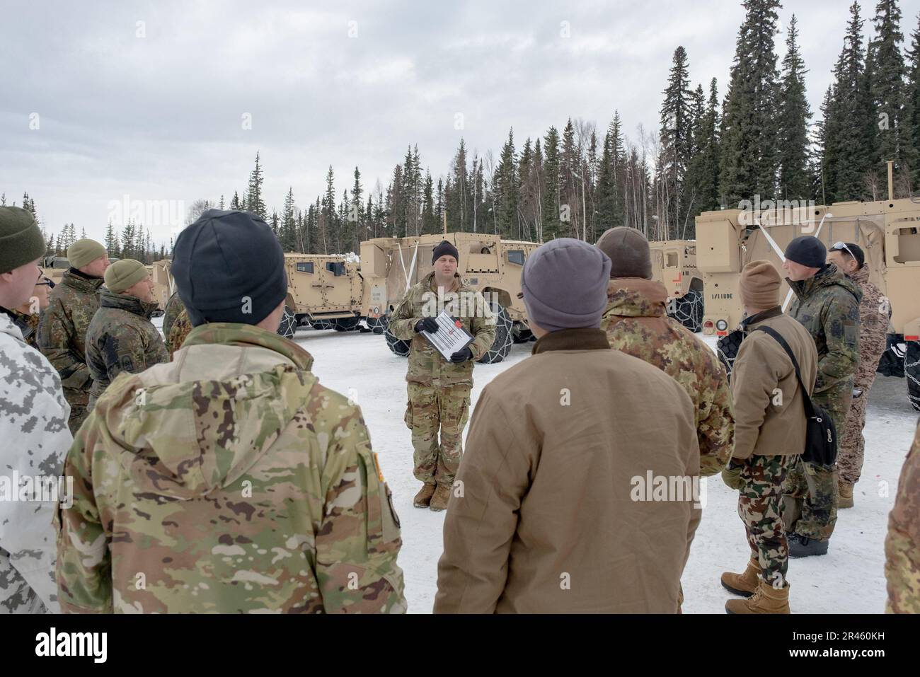 Captain Logan Tatter, 1. Brigaden-Kampfteam, 11. Luftwaffe, erläutert Funktionen des Joint Light Tactical Vehicle, die während des Joint Pacific Multinational Readiness Center-Alaska 23-02 internationalen Beobachtern aus mehreren Ländern am 27. März 2023 zur Verfügung gestellt werden. Mit mehr als 8.000 Teilnehmern und Beobachtern aus 12 verschiedenen Ländern trägt das multinationale Umfeld von JPMRC-AK 23 zur Verbesserung der arktischen Fähigkeiten der gesamten Armee und der gemeinsamen Truppe bei, um die Arktis-Strategie der Nation und der Armee zu unterstützen. Stockfoto