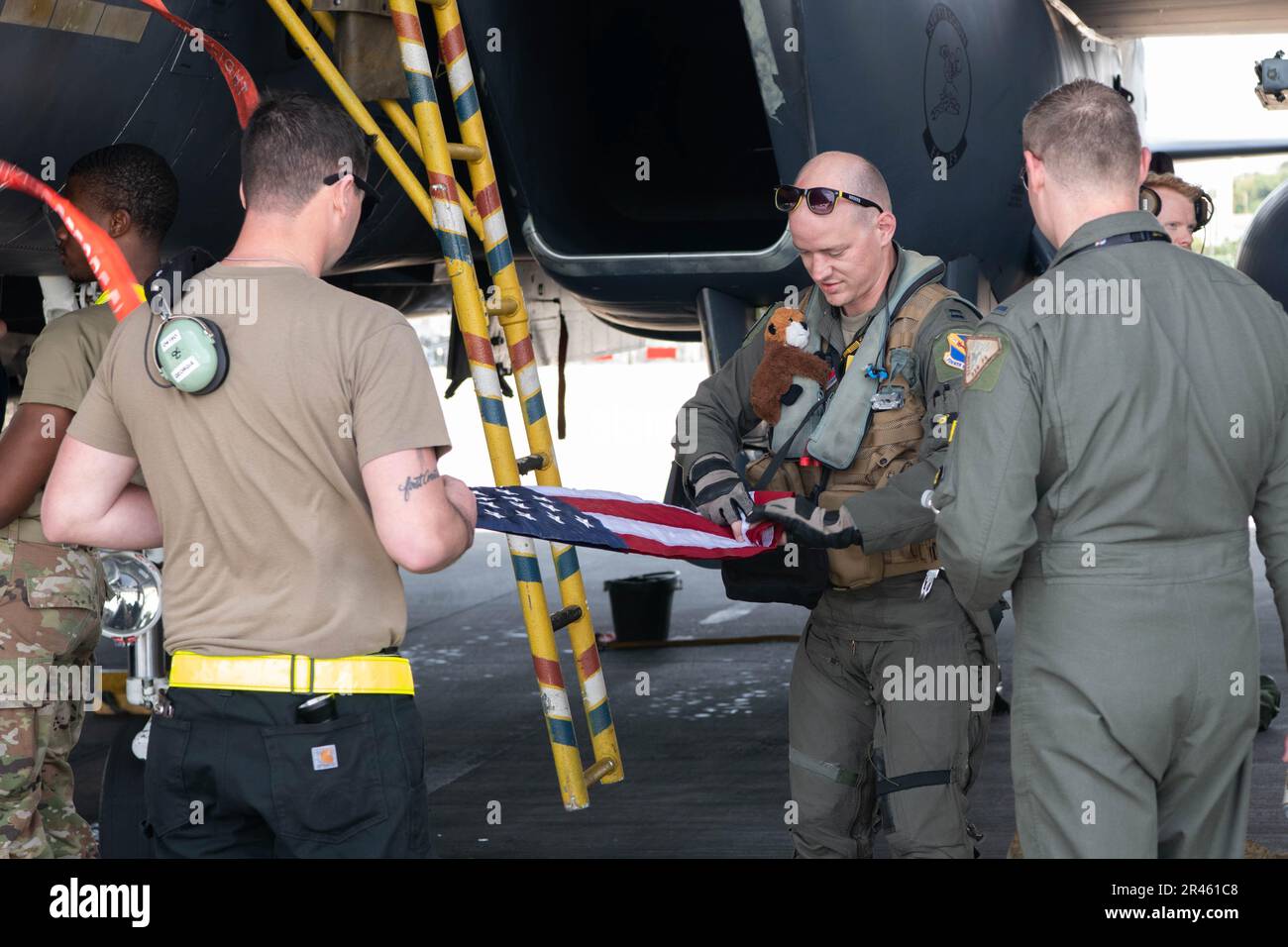 EIN US-AMERIKANISCHER Air Force F-15E Strike Eagle Pilot, der der 336. Kampfgeschwader zugeteilt wurde, und ein 336. Aircraft Maintenance Unit Betreuer falteten eine US-Flagge, nachdem er am Kadena Air Base, Japan, am 8. April 2023 ankam. Der Strike Eagle ist ein Doppelkämpfer mit Luft-zu-Luft- und Luft-zu-Boden-Missionen. Eine Reihe von Avionik- und Elektroniksystemen gibt der F-15E die Fähigkeit, in niedriger Höhe, Tag, Nacht und bei jedem Wetter zu kämpfen. Stockfoto