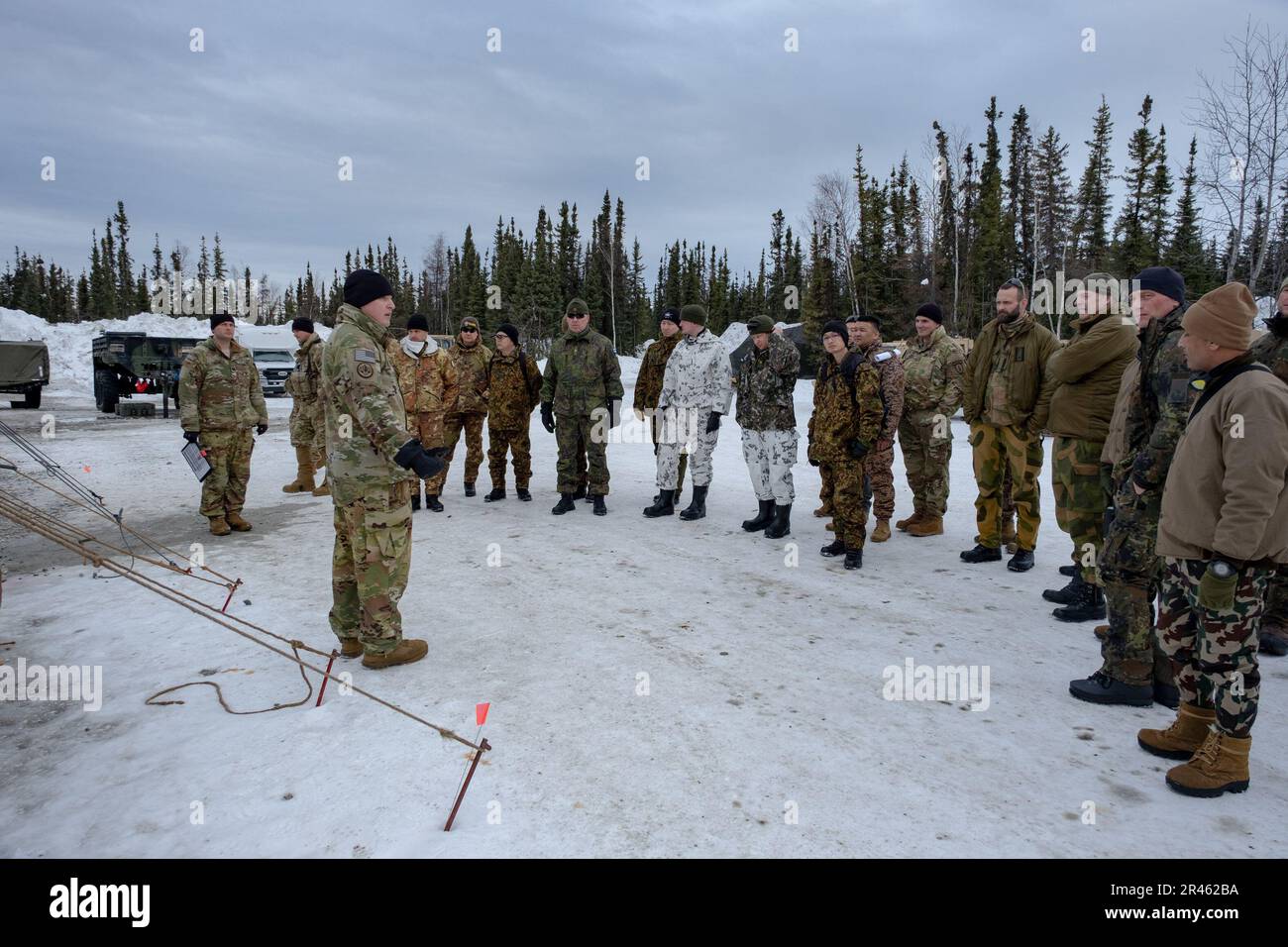 Captain Douglas Cichowicz, 1. Brigaden-Kampfteam, 11. Luftwaffendivision, erklärt den internationalen Beobachtern aus mehreren Ländern am 27. März 2023 die Merkmale von Winterzelten, die im Winterlager für das Joint Pacific Multinational Readiness Center-Alaska 23-02 verwendet werden. Mit mehr als 8.000 Teilnehmern und Beobachtern aus 12 verschiedenen Ländern trägt das multinationale Umfeld von JPMRC-AK 23 zur Verbesserung der arktischen Fähigkeiten der gesamten Armee und der gemeinsamen Truppe bei, um die Arktis-Strategie der Nation und der Armee zu unterstützen. Stockfoto