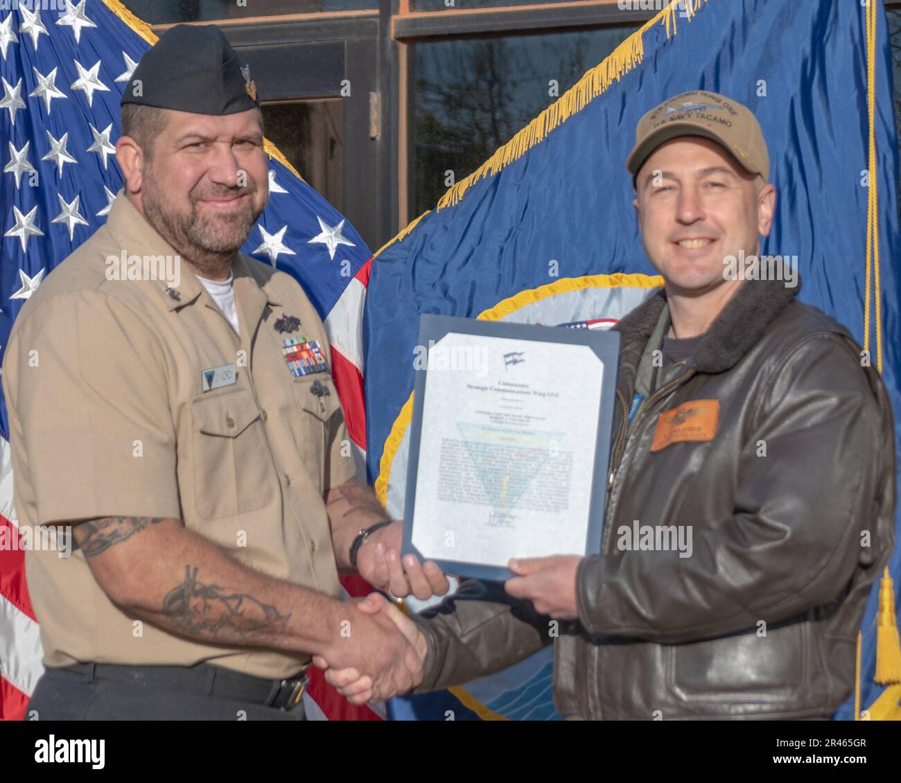 230406-N-MR862-0064 LUFTWAFFENSTÜTZPUNKT TINKER, OKLAISCH. (6. April 2023) Kapitän Robert ‚Skillz‘ Majoris, commodore, Strategic Communications Wing (SCW) 1, stellt Baumechaniker 1. Klasse Robert Towndrow bei einem Preisverleihungsquartal am 6. April 2023 mit einem Bestätigungsschreiben vor. SCW-1 ist ein Mieter des Kommandos der Marine-Luftwaffe, der die nationale Sicherheit durch die Abschreckung gegensätzlicher nuklearer Ambitionen gewährleistet. Stockfoto