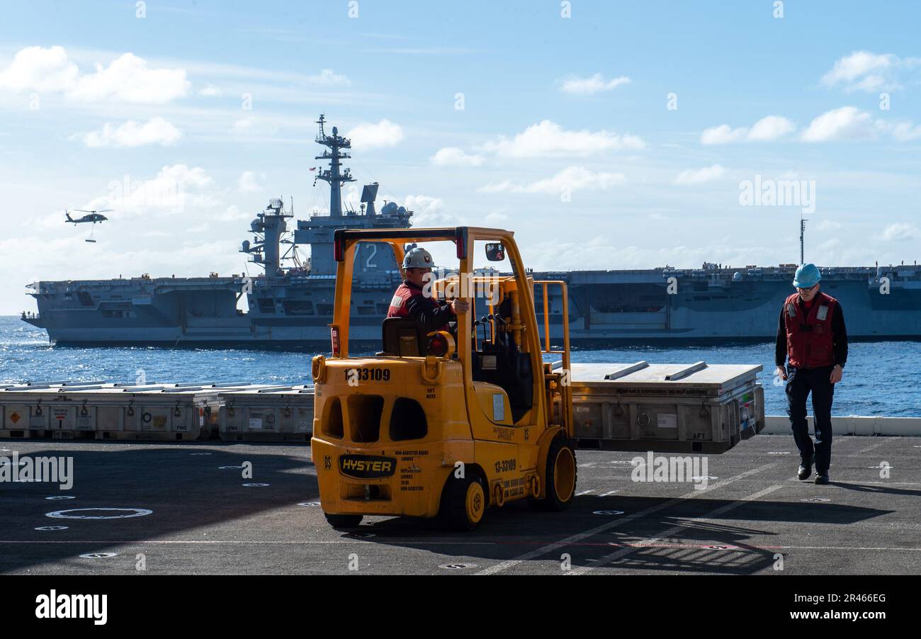 230118-N-MD461-1130 PACIFIC OCEAN (18. Januar 2022) Aviation Ordnanceman 3. Class Jeffrey Bokano, Center, ein Einheimischer aus Hudson Valley, N. Y., transportiert Kampfmittel mit einem Gabelstapler, während Aviation Ordnanceman Airman Apprentice Ayadn Hastings, ein Einheimischer aus Aurora, Ind., auf Sicherheit während eines Flugzeugs der USIMITT-Klasse Carl achtet (CVN 70) und Flugzeugträger der Nimitz-Klasse USS Abraham Lincoln (CVN 72). Vinson führt derzeit routinemäßige Seeeinsätze durch. Stockfoto