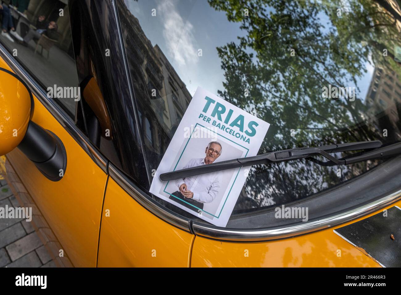 Ein Wahlposter des ehemaligen Bürgermeisters und Kandidaten Xavier Trias auf der Windschutzscheibe eines Fahrzeugs, das im oberen Teil der Diagonal geparkt ist. Wenige Stunden nach Ende der Wahlpropagandazeit sind einige Wahlplakate sichtbar, die Zeichen von Vandalismus oder kritischen Veränderungen durch Oppositionsgruppen zeigen. Stockfoto