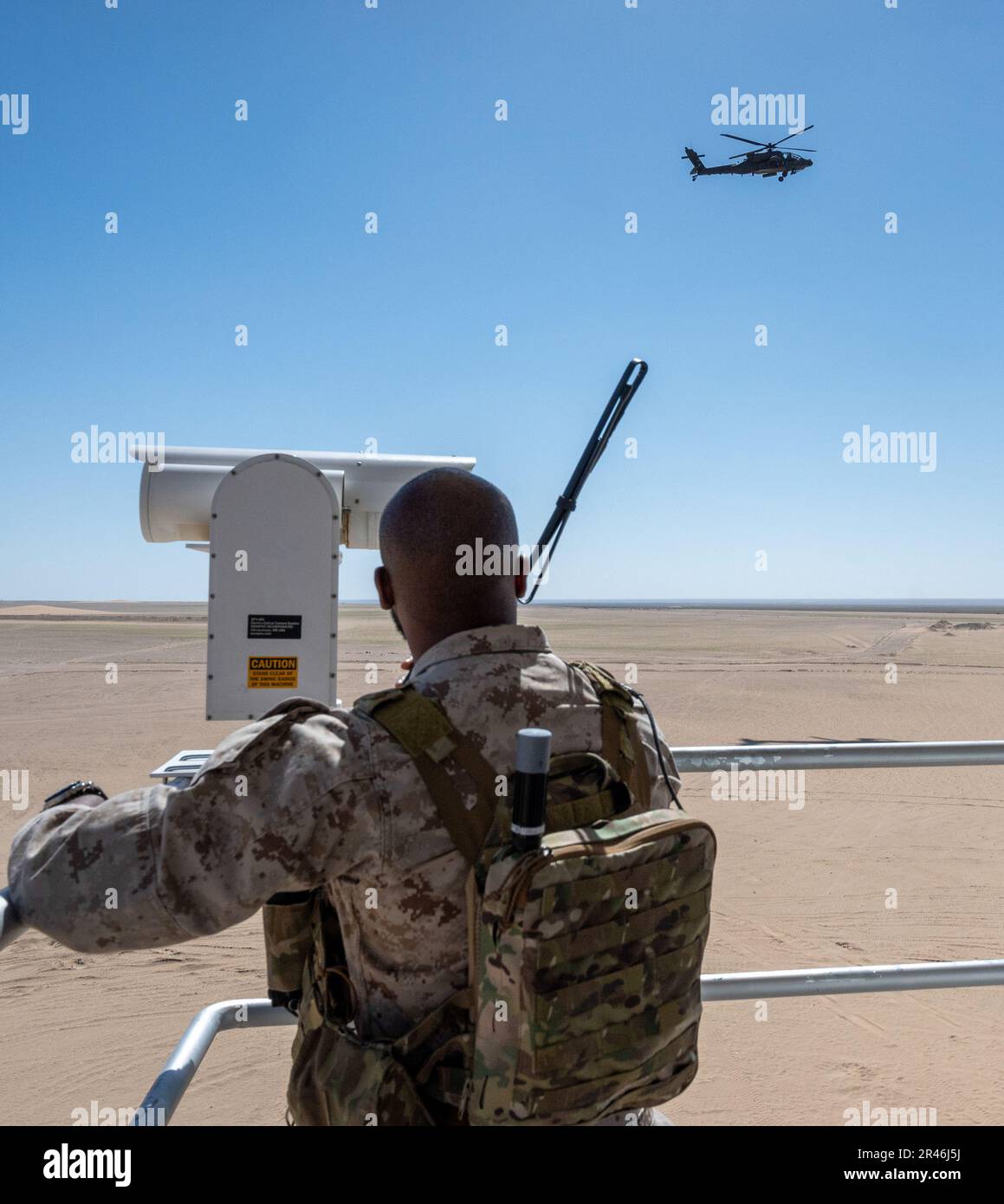 EIN US-AMERIKANISCHER Marine Task Force 51/5 Joint Tactical Air Controller, Funkverbindung zu einem AH-64 Apache Helikopter während des Trainings am Udairi Range, Kuwait, 4. April 2023. Während des Trainings koordinierten taktische Air Force Air Control-Gruppen und Marine-JTACs Trockenfeuer auf Ziele mit AH-64-Apachen der Armee. Diese gemeinsame Schulung zwischen den USA Luftwaffe, USA Marines und USA Armee, verbessert die Koordination zwischen Luft- und Bodenressourcen, wodurch Feuer schneller und mit höherer Genauigkeit auf Ziele in Stresssituationen gebracht wird. Stockfoto