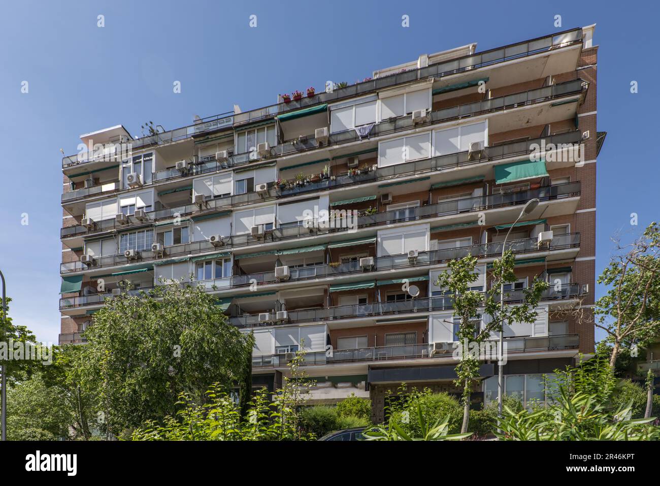 Fassade eines Wohngebäudes mit großen Terrassen, von denen einige mit weißem Aluminium verschlossen sind Stockfoto