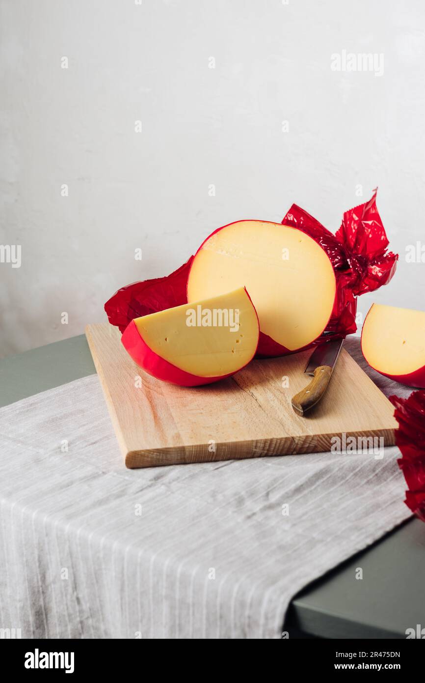 In Scheiben geschnittener Edamskäse, mit roter Wachsschicht bedeckt. Stockfoto