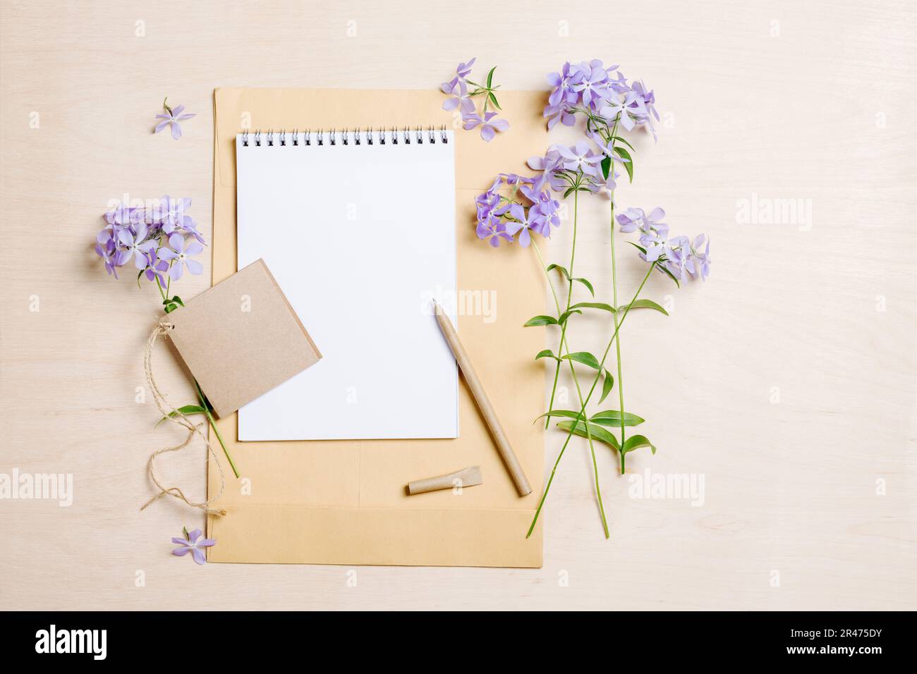 Sommermockup-Szene. Leeres Notizbuch, Stift und blaue Blumen auf Holzhintergrund, flach liegend, Ansicht von oben, Kopierbereich. Stockfoto