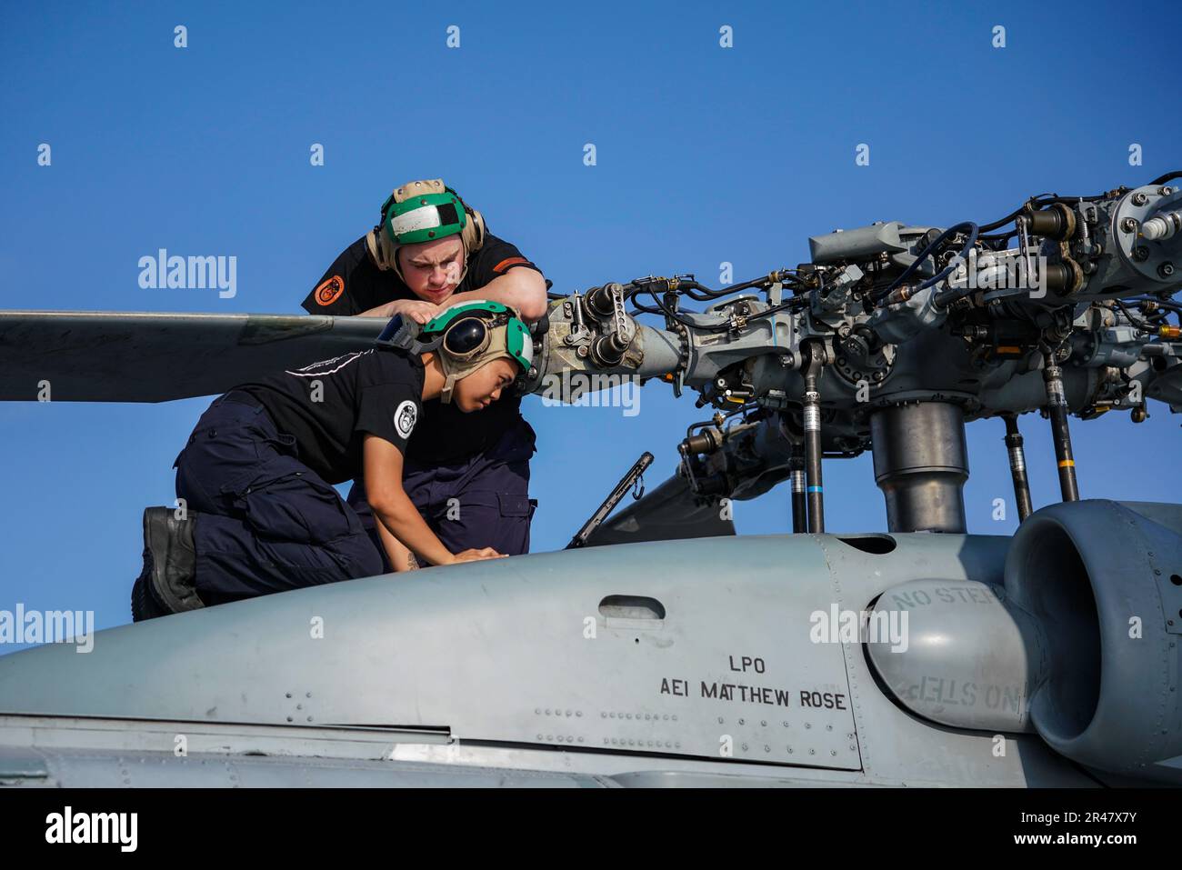 SINGAPUR (16. März 2023) Aviation Structural Mechanic 2. Class Dianeerika Asuncion, Front, from Kahului, Hawaii, und Aviation Structural Mechanic 3. Class Joshua Imperati, from Poughkeepsie, New York, beide zugewiesen zu Helicopter Maritime Strike Squadron (HSM) 35, führen Wartungsarbeiten am Hauptrotor eines MH-60R SeaHawk, angeschlossen an HSM-35, durch Auf dem Cockpit des Kampfschiffs USS Oakland (LCS 24) der Unabhängigkeitsklasse am Marinestützpunkt Changi, Singapur, 16. März 2023. Oakland, Teil der Destroyer-Geschwader 7, ist in Rotation im US-7.-Flottengebiet Stockfoto