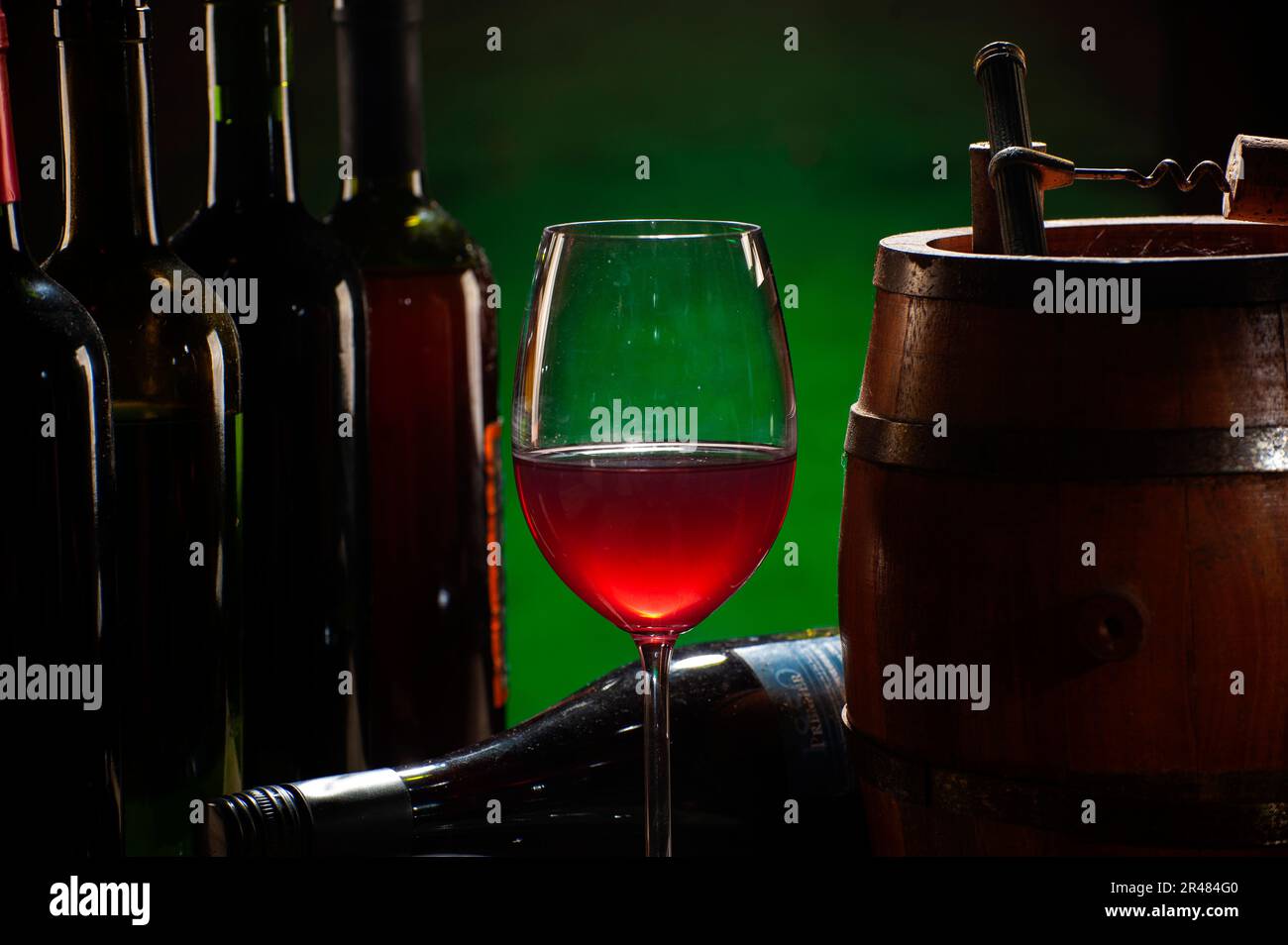 Glas und Flaschen Rotwein auf dem Tisch Stockfoto