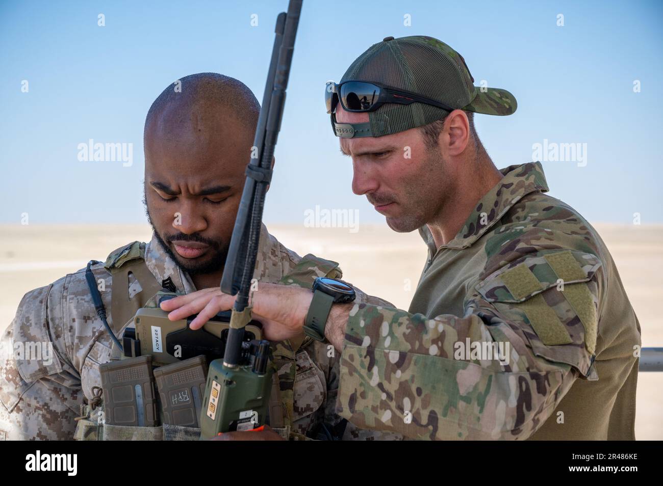 EIN US-AMERIKANISCHER Marine Task Force 51/5 Joint Tactical Air Controller und ein US-amerikanischer Air Force Airman vom 82. Taktischen Flugkontrollteam der Expeditionary Air Support Operations Squadron, ging während des Trainings am Udairi Range, Kuwait, 4. April 2023 eine Karte durch. Während des Trainings koordinierten Air Force TACPs und Marine JTACs Trockenfeuer auf Ziele mit AH-64-Apachen der Armee. Diese gemeinsame Schulung zwischen den USA Luftwaffe, USA Marines und USA Armee, verbessert die Koordination zwischen Luft- und Bodenressourcen, wodurch Feuer schneller und mit höherer Genauigkeit auf Ziele in Stresssituationen gebracht wird. Stockfoto